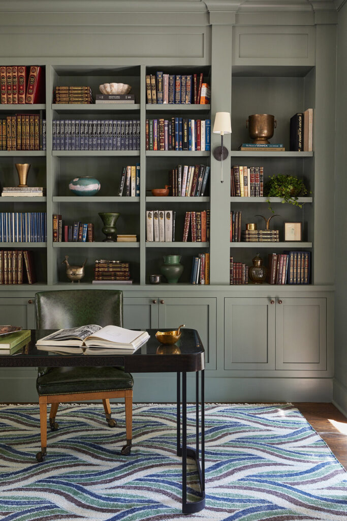 Home office with a wall of bookshelves and patterned rug