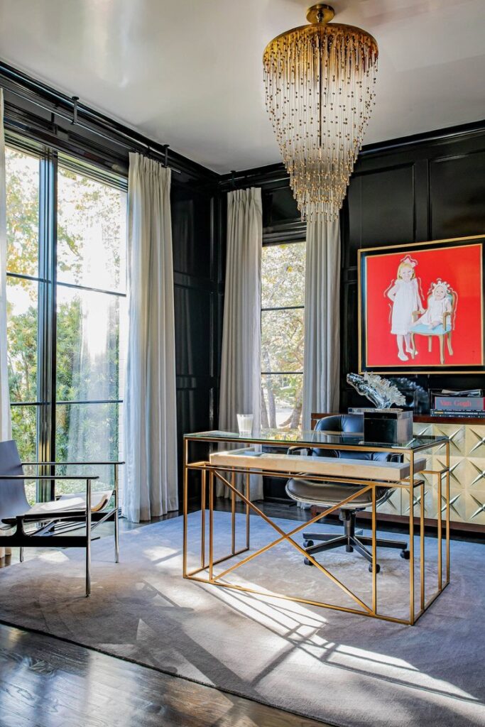 Modern home office with red wall art, modern glass desk, and black painted walls