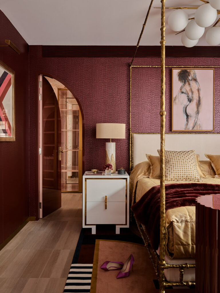 wine colored walls and camel colored headboard and lamp
