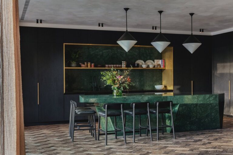 Dark walls and green island in kitchen