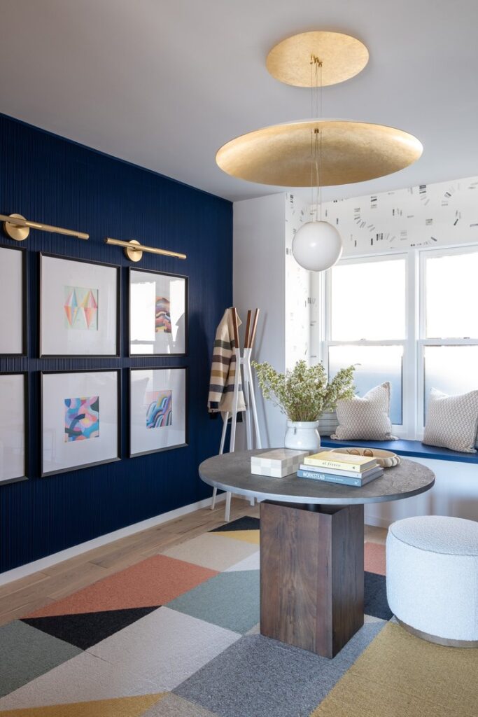 Blue accent wall with framed photos and lighting