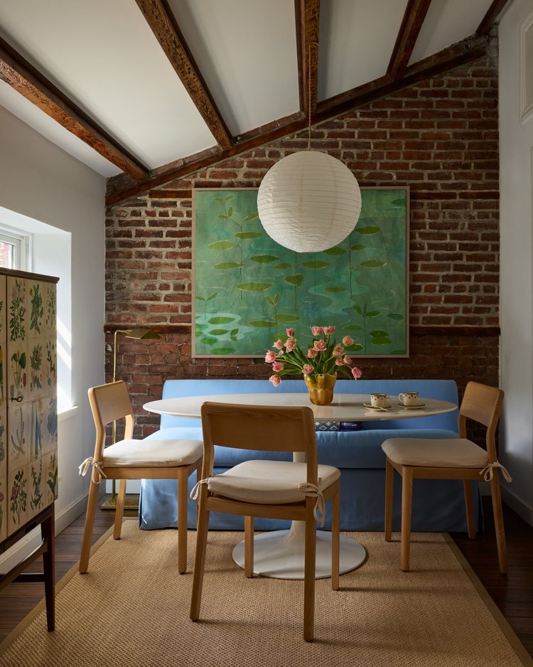 brick wall in a living room with green wallet and blue couch