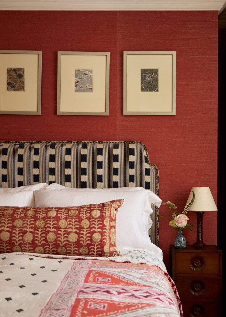red bedroom wall with pillows in different patterns