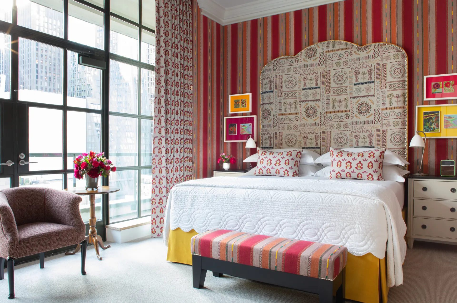 A brightly striped wallpapered guest room at The Whitby Hotel in New York City