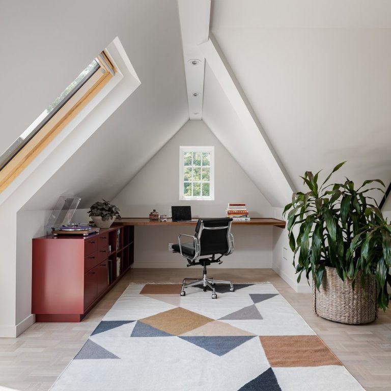 Home office with slanted ceiling and large greenery