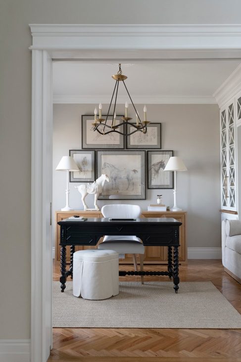 Home office with layer lighting that includes two desk lamps and a chandelier