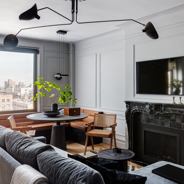 Apartment with small corner table, couch, and fireplace